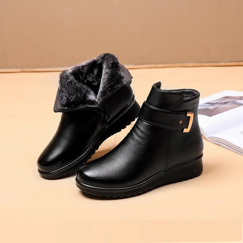 Pair of black leather ankle boots with grey fur-lined collar shown folded down beside a magazine