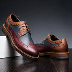Detail view of the burgundy and navy panelled upper with tan brogue trim and perforated edging