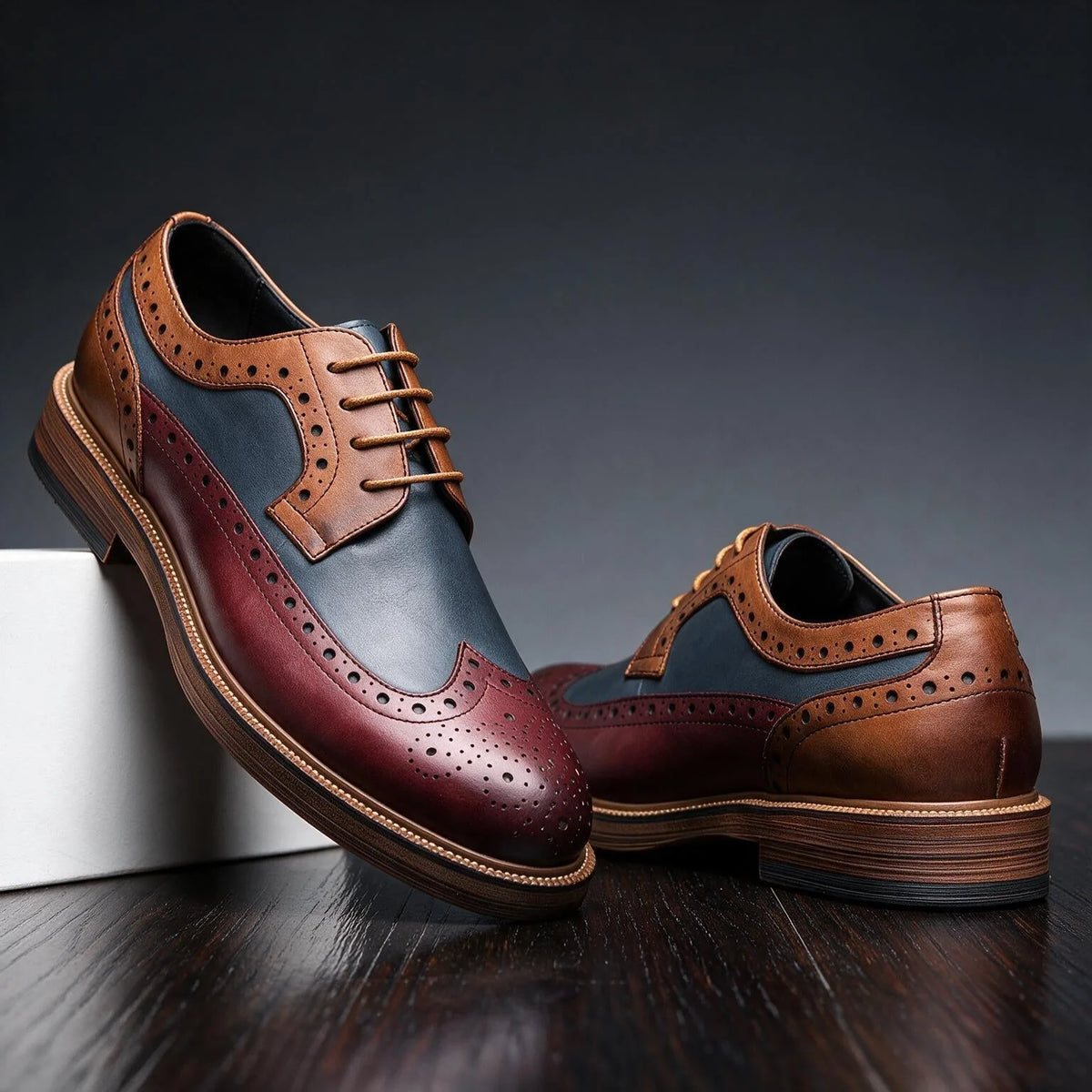 Detail view of the burgundy and navy panelled upper with tan brogue trim and perforated edging