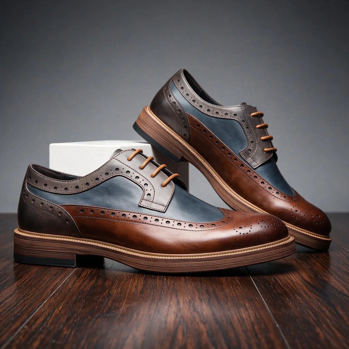 Front angle of the brown, navy and grey brogue derby shoe showing the wingtip toe cap and lacing