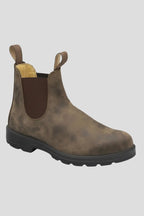 Angled view of a brown leather Chelsea boot with elastic side panel and rounded toe, black tread sole