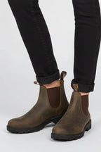 Close-up of black skinny trousers cuffed above brown leather Chelsea boots with pull tab detail