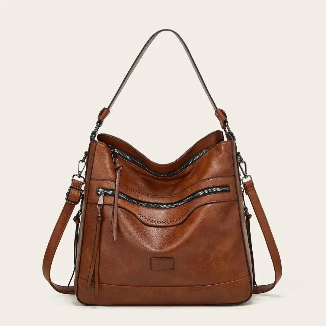 Tan brown faux leather hobo bag with slouchy silhouette, front zip pockets and tall shoulder handle