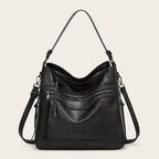 Black faux leather hobo shoulder bag shown from the front with double zip pocket detail and tassel pull
