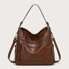 Brown hobo bag with open top zip revealing the roomy interior and adjustable crossbody strap