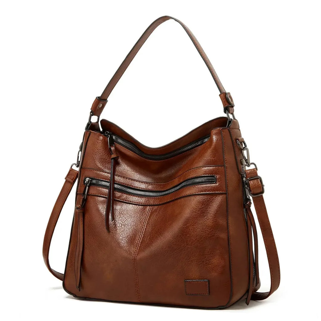 Side angle of a brown leather-look hobo bag highlighting the curved silhouette and dual shoulder straps