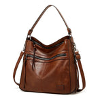 Side angle of a brown leather-look hobo bag highlighting the curved silhouette and dual shoulder straps