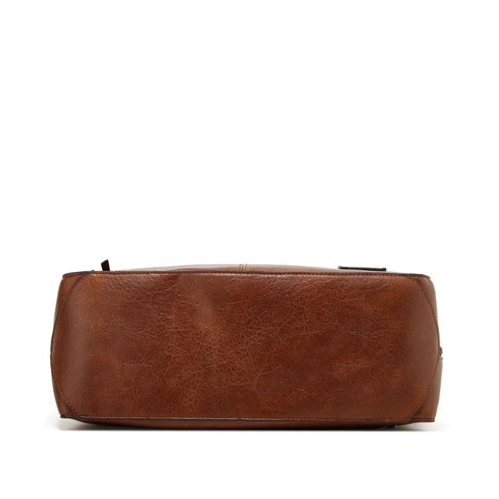 Side profile of the brown hobo bag showing its rounded base, tall handle and side zip pull