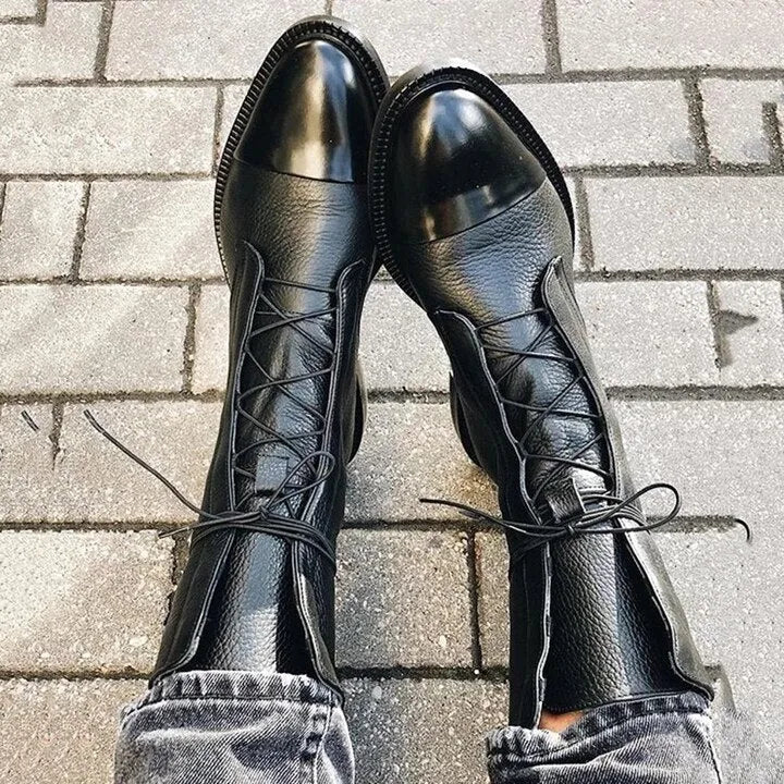 Overhead view of black leather lace-up boots seen from above, showing the pointed cap toe