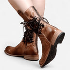 Back view of tan brown leather boots highlighting the side zip, lace-up shaft and stacked block heel
