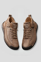 Top view of a pair of tan leather lace-up trainers with SPORT branded strap and stitched sole detail