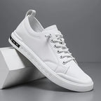 Side view of a white leather trainer with lace-up front, textured sole and stitched toe detailing
