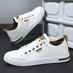 Side profile of white trainer showing tan brand patch, embossed sole trim and olive midsole stripe