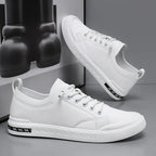 Pair of white leather trainers shown together, one resting on its side, with ridged white outsole