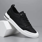 Side profile of a black leather trainer with lace-up closure and contrasting white textured outsole