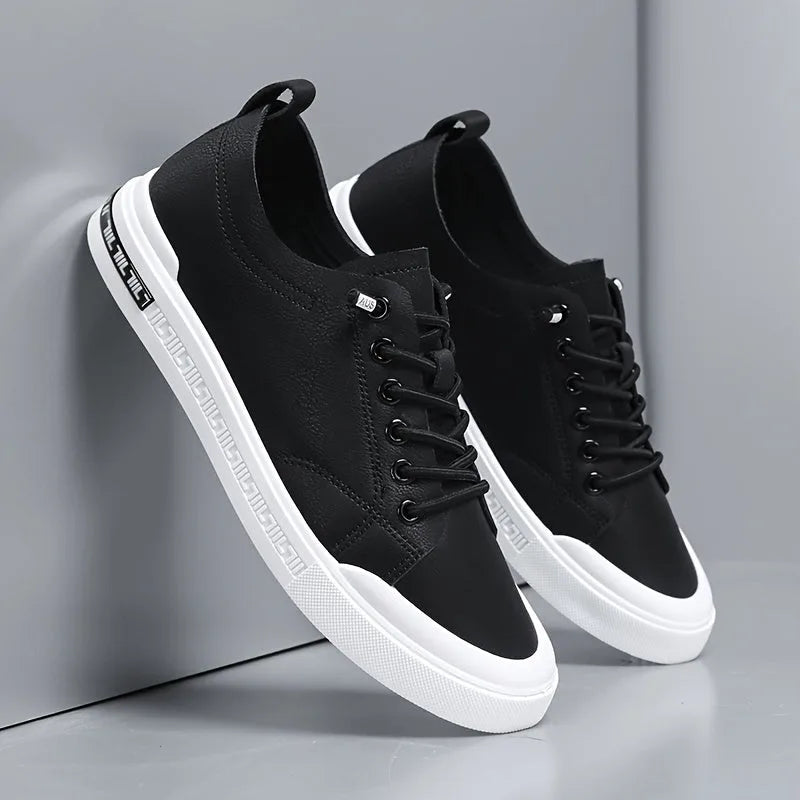 Close-up side angle of black leather trainers leaning together, highlighting stitching and sole trim
