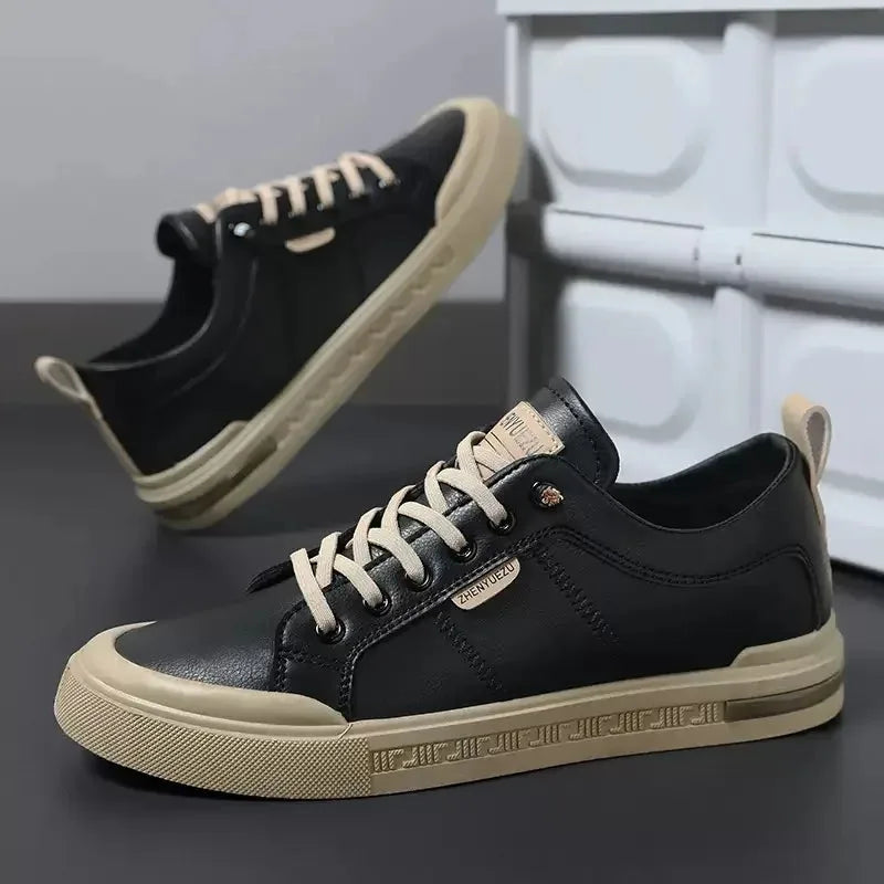 Side profile of black trainer showing cream heel tab, tan midsole trim and embossed sidewall pattern