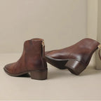 Pair of black leather ankle boots showing V-cut topline and back zip fastening