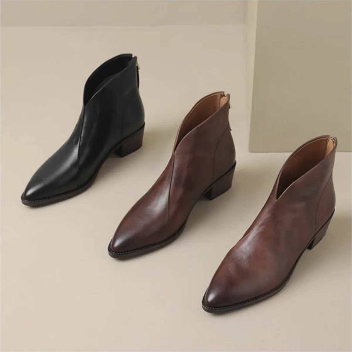 Back and side view of brown leather ankle boots with low block heel and zip closure