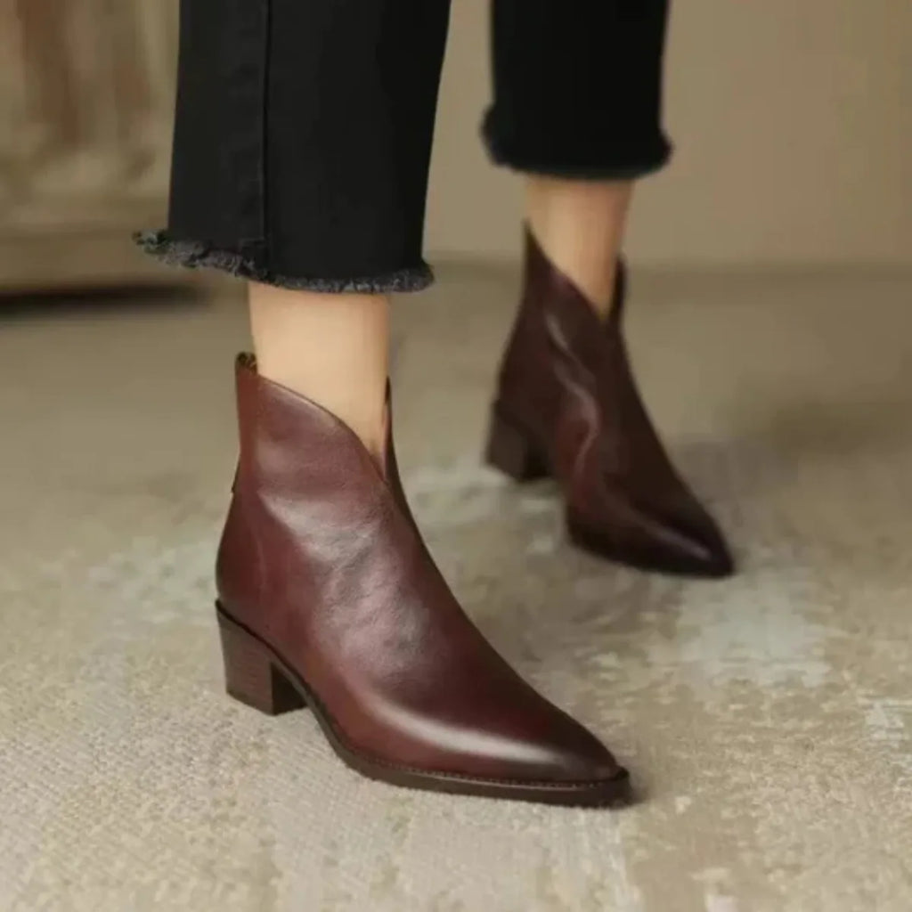 Model wearing black leather ankle boots with cropped denim jeans, front walking view