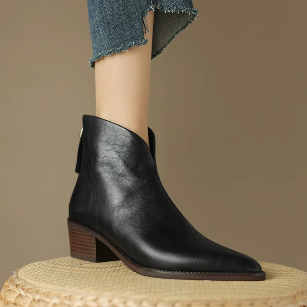 Side close-up of dark brown leather ankle boot showing pointed toe and stitched sole detail