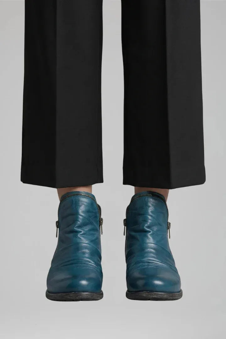 Front view of the ankle boot style in a deep teal blue leather with visible side zip