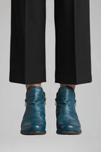 Front view of the ankle boot style in a deep teal blue leather with visible side zip