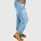 Side profile of relaxed-fit denim jeans showing back pocket detail and rolled-up ankle cuffs