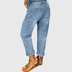 Rear view of light wash denim trousers highlighting the loose, straight-leg silhouette and back pockets