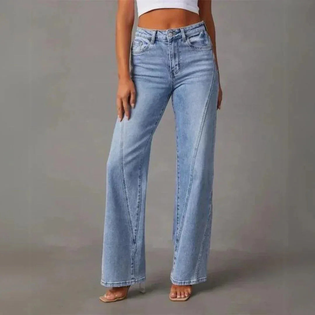 Front view of the wide-leg jeans styled with a white crop top, highlighting the diagonal seam design