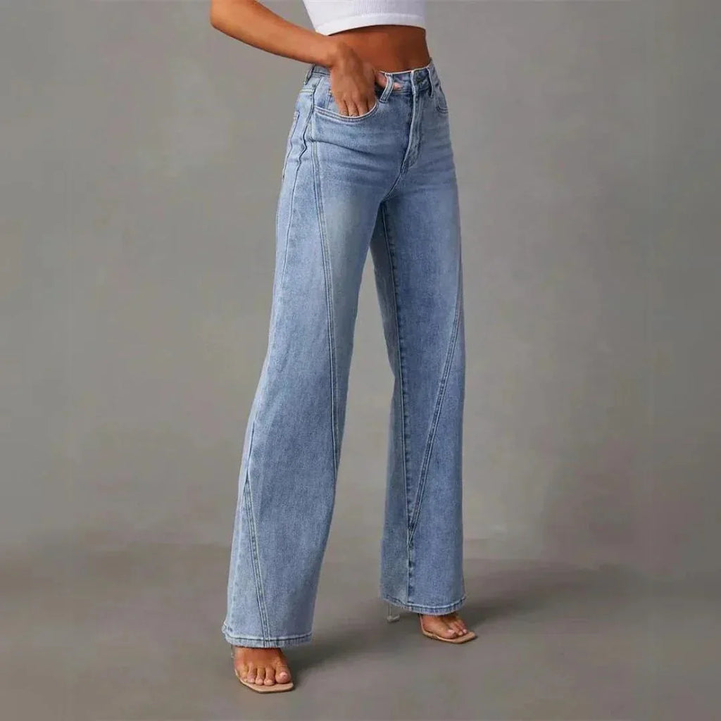 Close-up of the waistband and pocket detail on the high-waisted light blue denim trousers