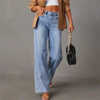 Model walking in the wide-leg jeans holding a black chain-strap handbag, side front view