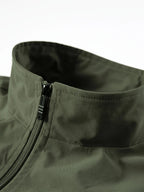 Close-up of olive green gilet collar with zip pull and reinforced stitching at the neckline