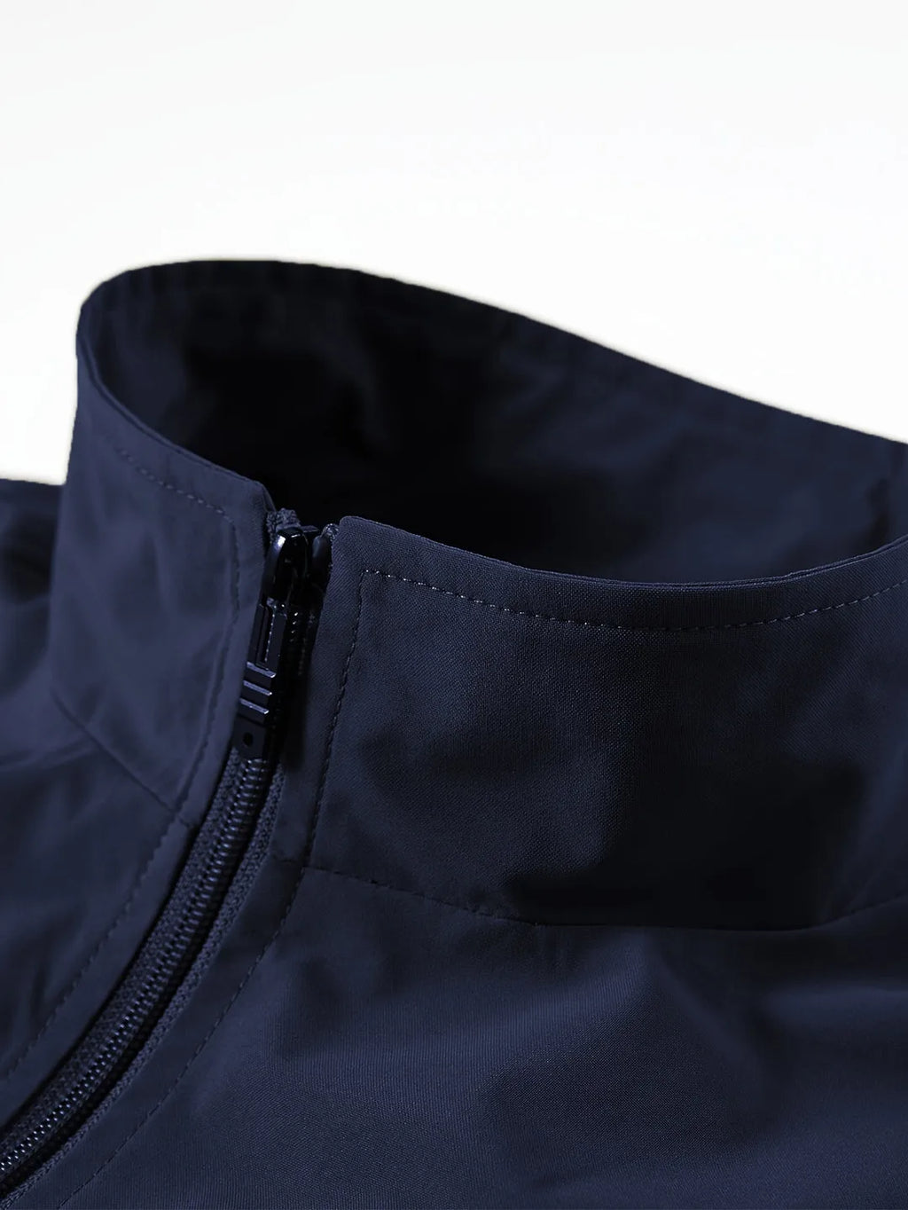 Close-up of navy gilet collar showing stand-up neck, zip fastening and smooth fabric finish