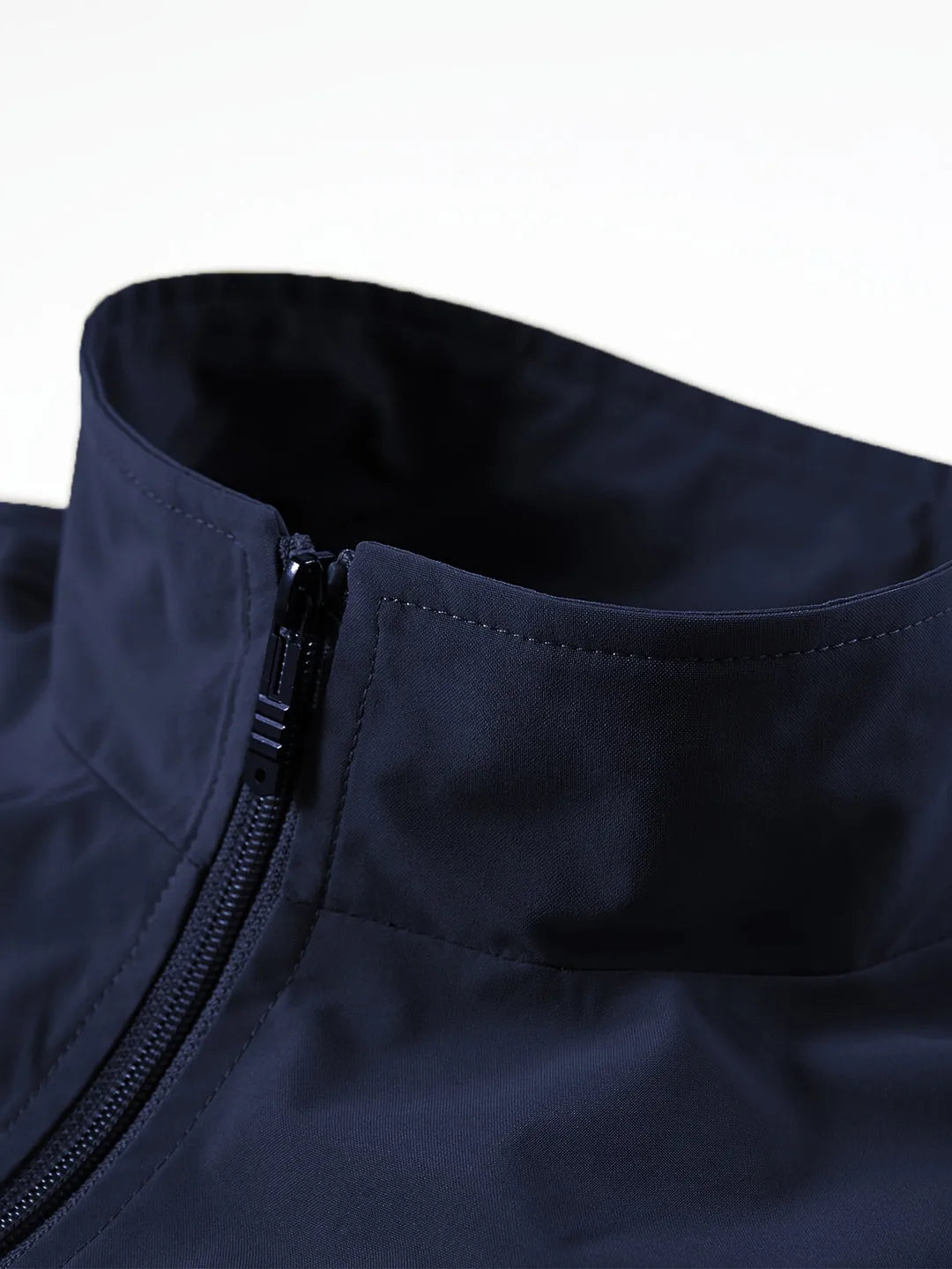 Close-up of navy gilet collar showing stand-up neck, zip fastening and smooth fabric finish