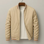 Beige bomber jacket on a wooden hanger, open zip showing a white t-shirt underneath, front view