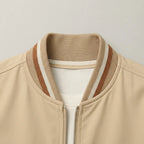 Close-up of the ribbed collar with rust, white and beige stripes and the front zip detail