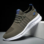 Side view of military green knit trainer with blue laces and heel tab, white chunky sole on grey background