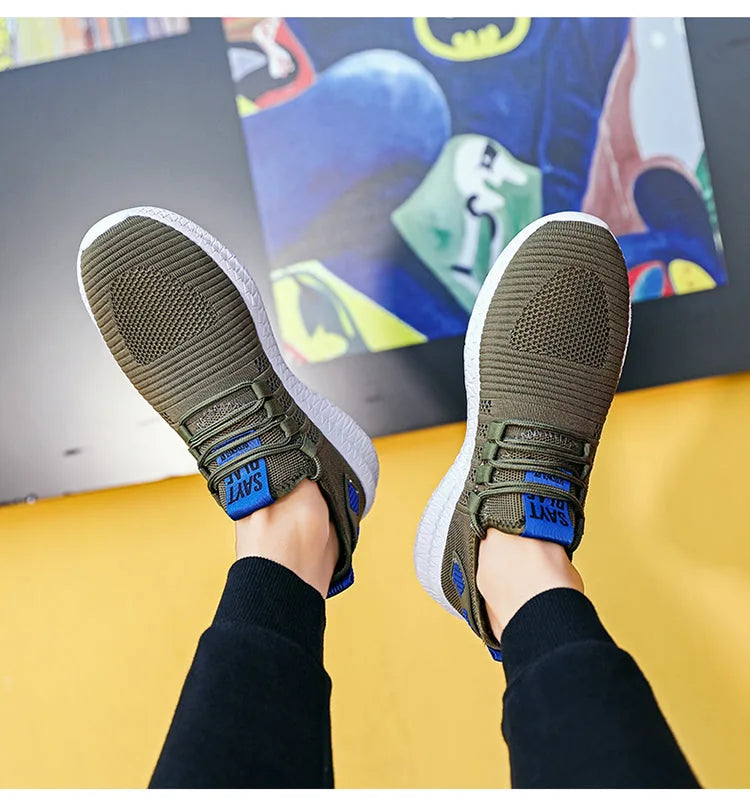 Top-down view of a pair of military green knit trainers with blue laces and white soles, feet raised