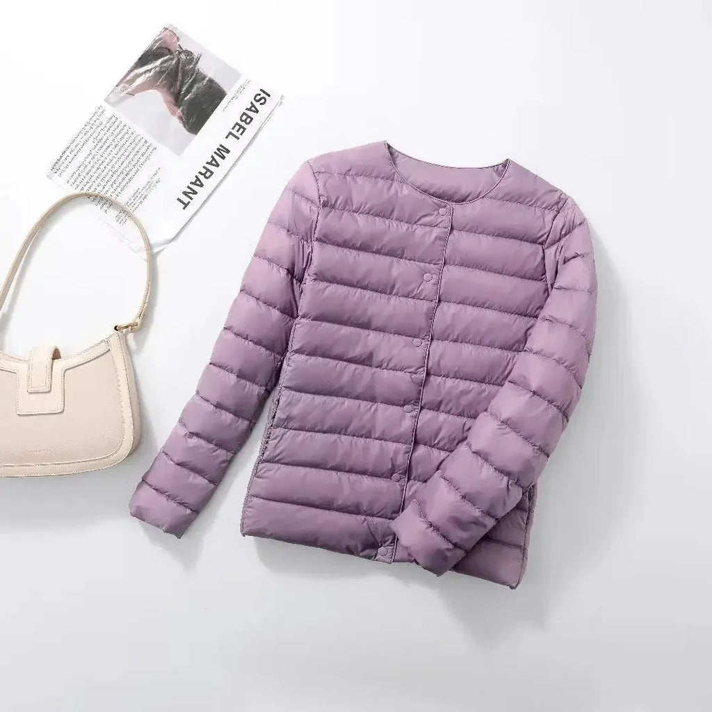Light purple quilted lightweight jacket laid flat with a cream shoulder bag nearby