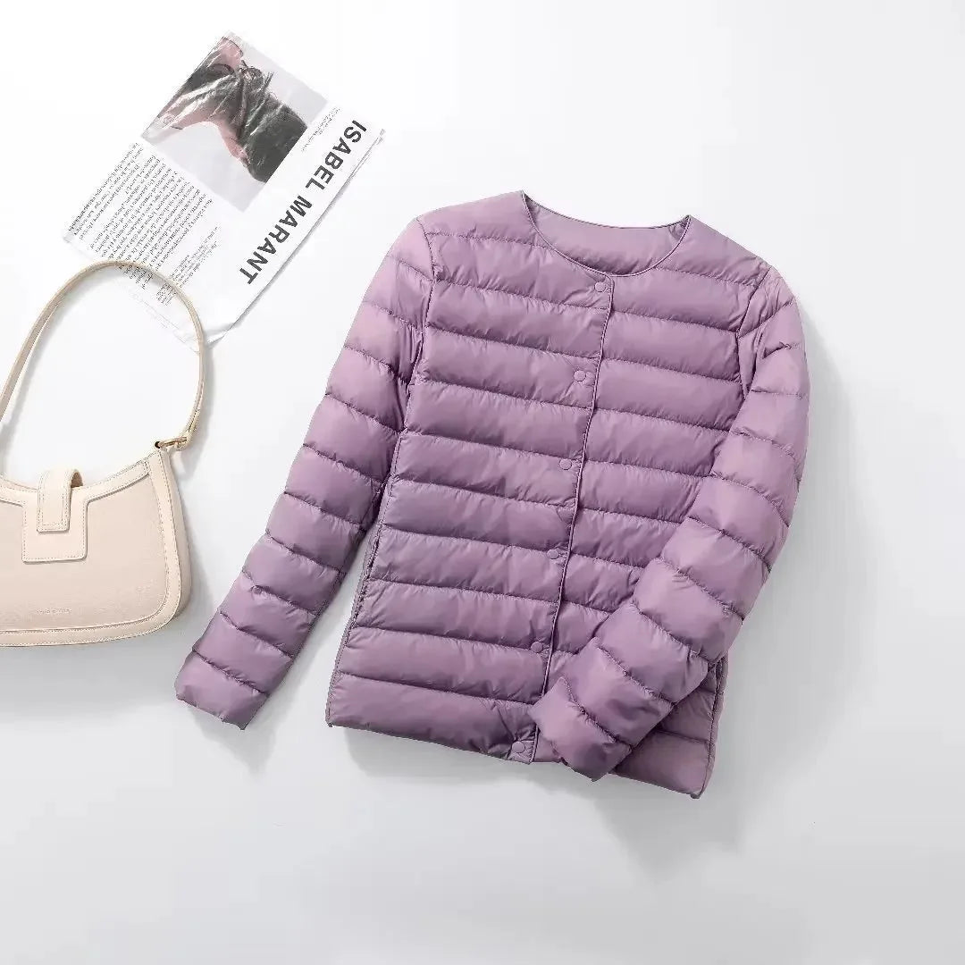 Light purple quilted lightweight jacket laid flat with a cream shoulder bag nearby
