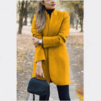 Mustard yellow longline blazer coat with stand collar and tailored fit worn with black trousers