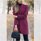 Deep magenta longline tailored coat with stand collar draped open over the shoulders