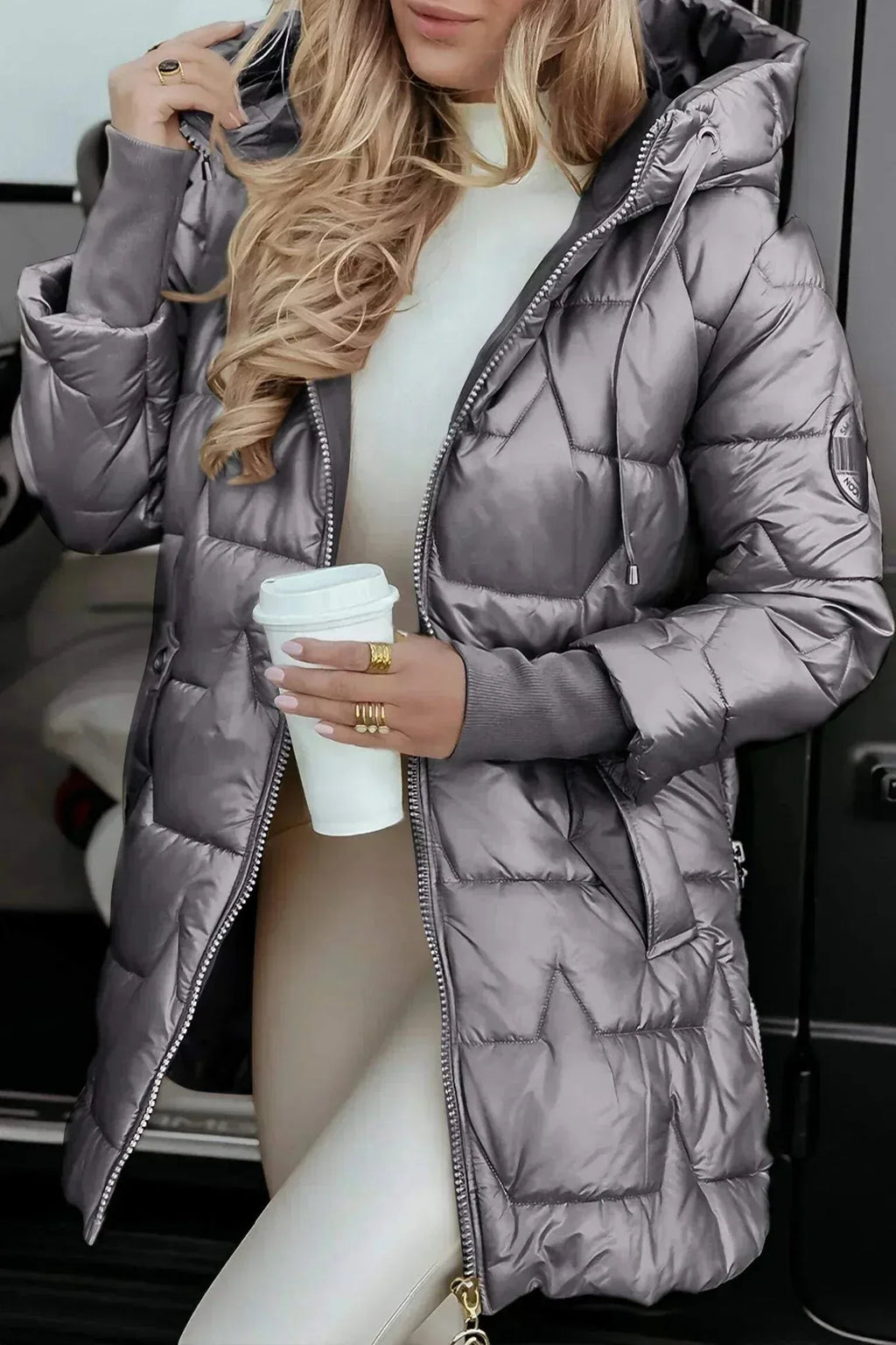 Side view of the same puffer coat in a warm bronze tone showing quilted star stitching and ribbed cuffs