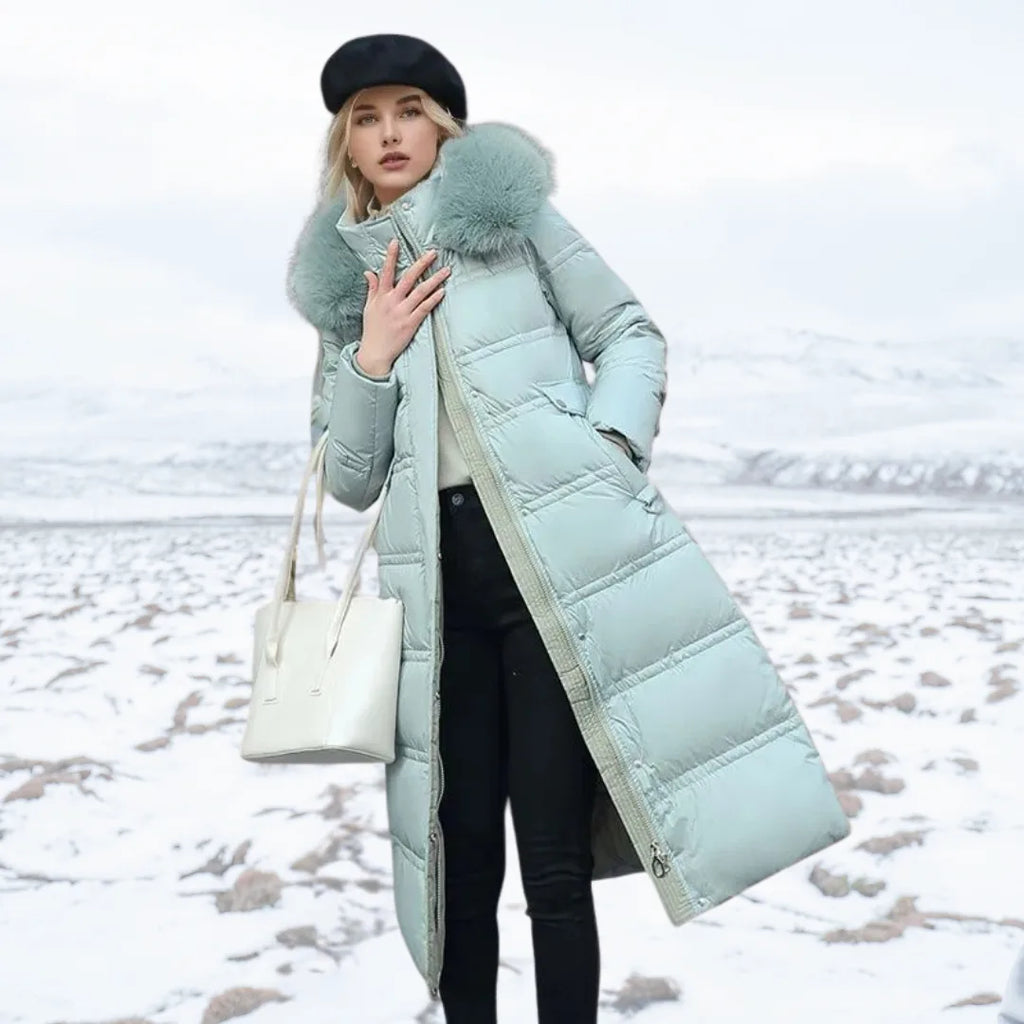 Woman adjusting the plush fur hood of a brown puffer coat while holding a smartphone