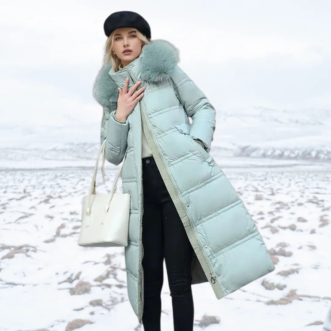 Woman adjusting the plush fur hood of a brown puffer coat while holding a smartphone