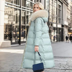 Model walking on a cobbled street showcasing the full-length drape of the black puffer coat