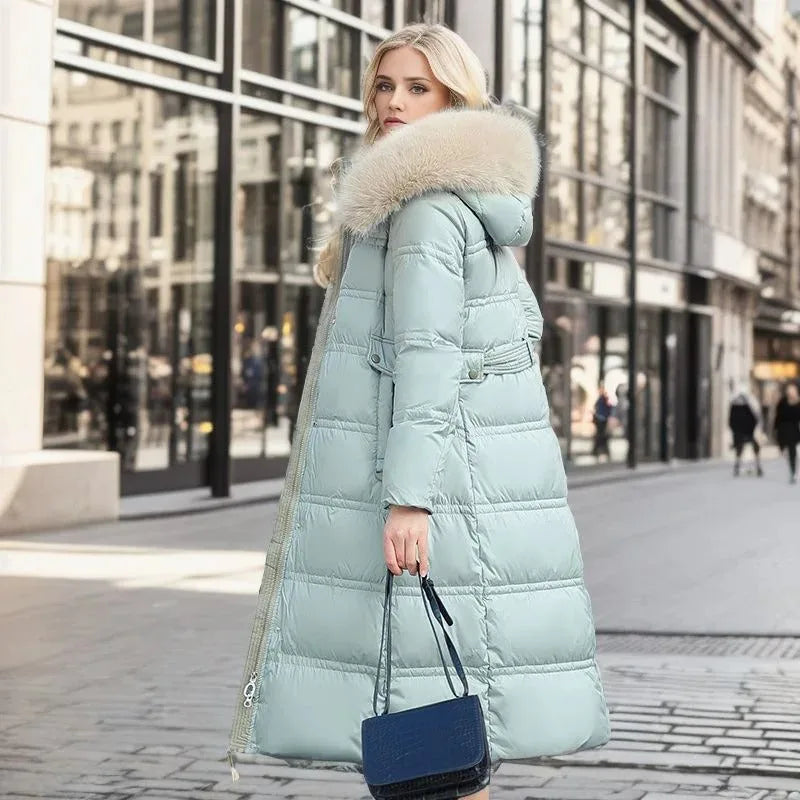 Model walking on a cobbled street showcasing the full-length drape of the black puffer coat