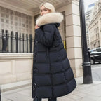 Rear side view of black quilted coat with cream fur hood walking past a city storefront