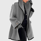 Grey longline coat with black contrast binding, relaxed drape and structured shoulder